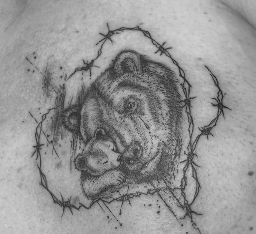 Gorilla, eingerahmt von feinen Linien, als Tattoo auf der Brust.