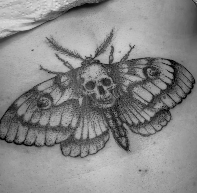 Großer Falter mit Schädelzeichnung als Tattoo.