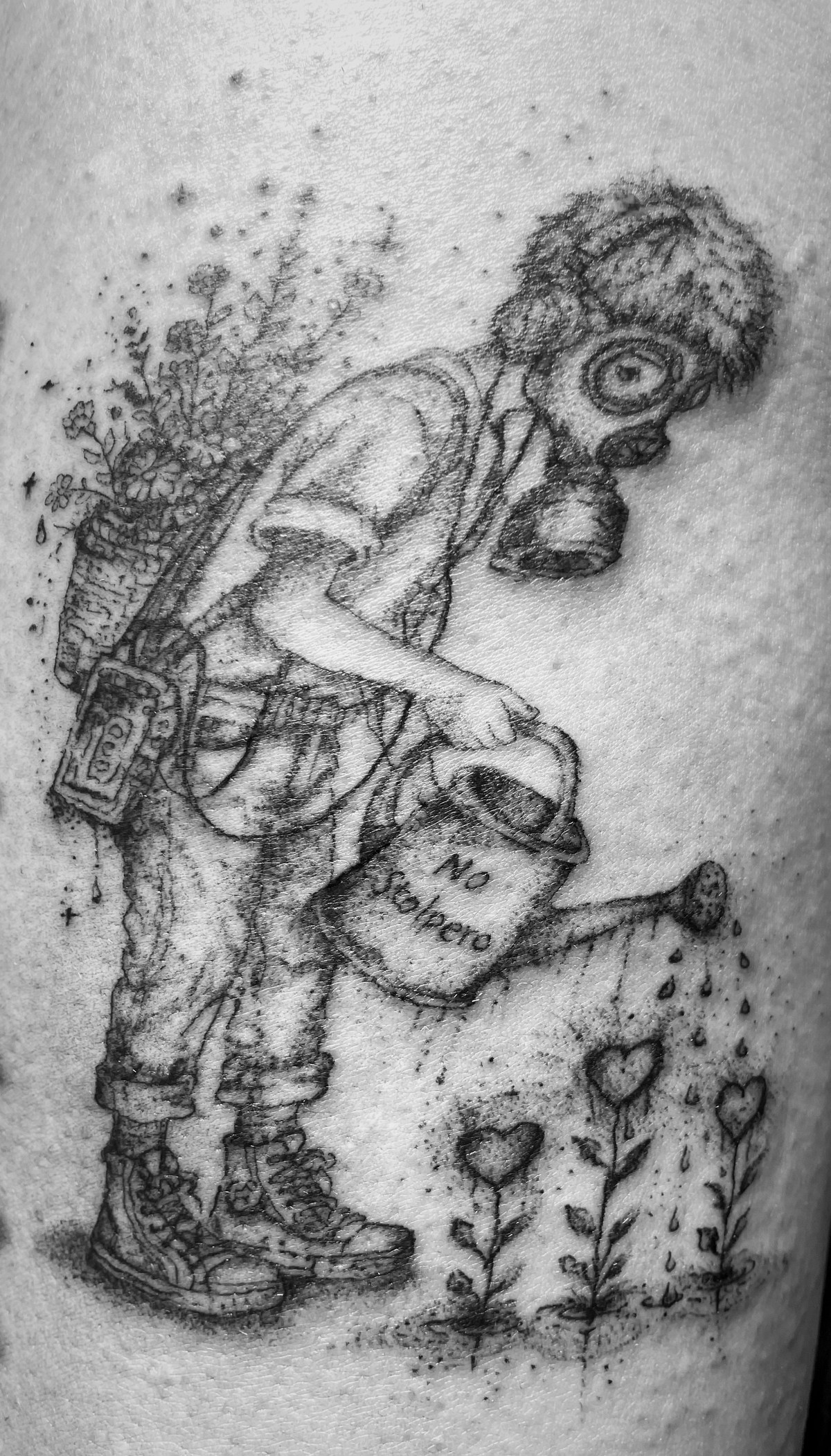 Figur mit Atemmaske und Gießkanne neben Blumen als Tattoo.