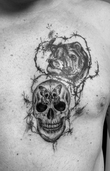 Totenkopf unter einem Gorilla, verbunden durch Stacheldraht, als Tattoo auf der Brust.
